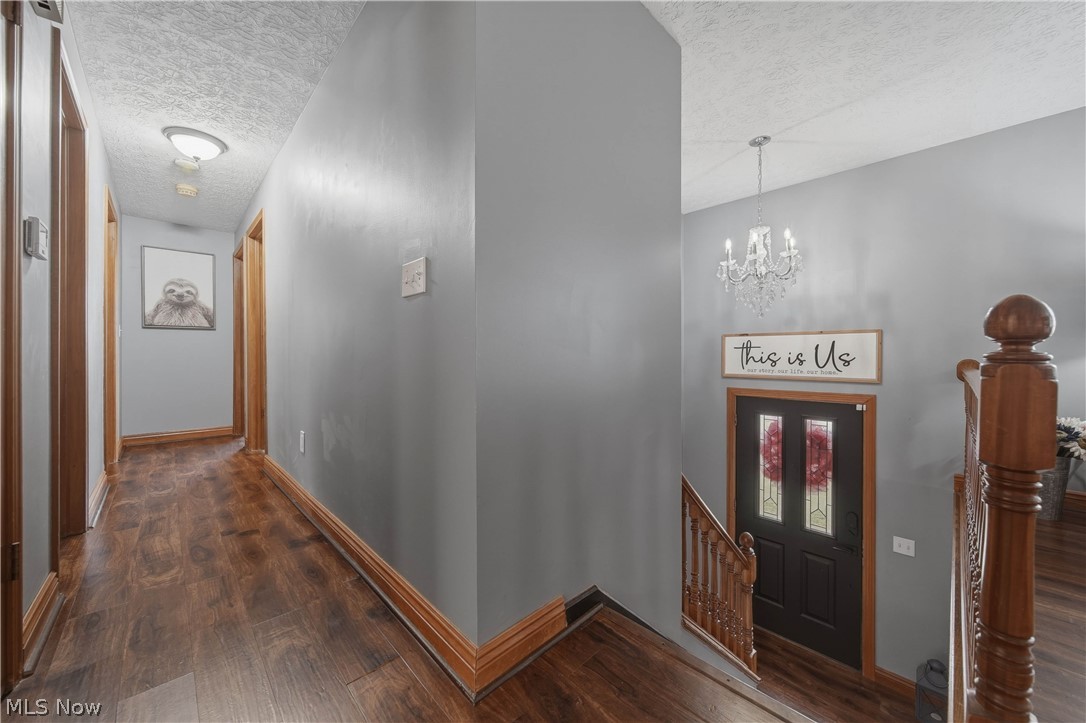 702 Perry Drive Northwest Canton, OH 44708 - Photo 14 of 46 Foyer featuring a textured ceiling, a chandelier, and dark wood-style floors