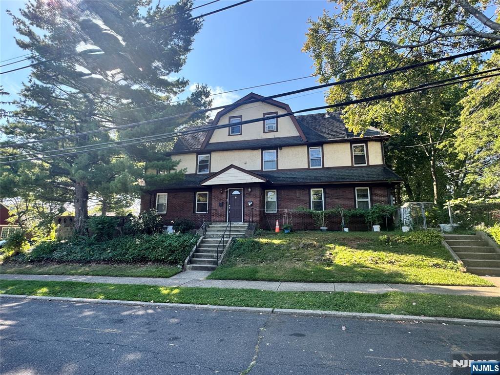 a view of a big building with a big yard and large trees