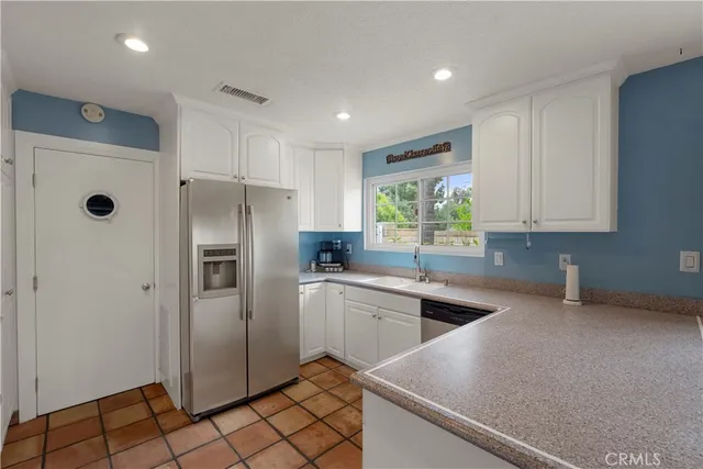 a kitchen with white cabinets and appliances