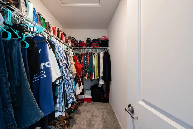 a view of walk in closet with clothes