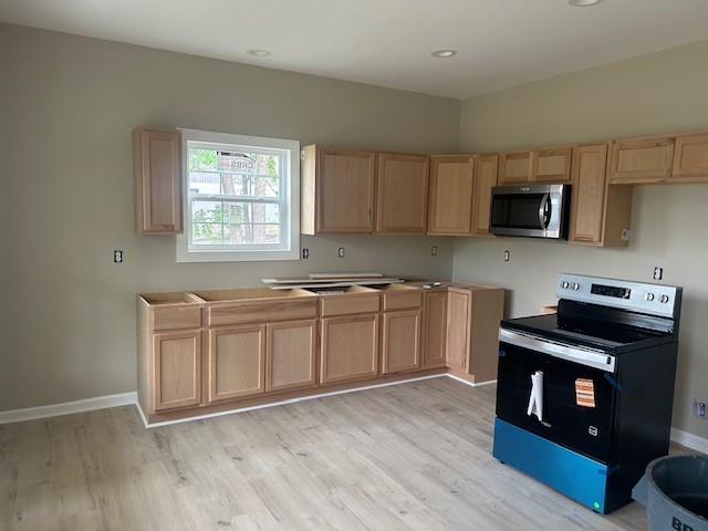 402 North 3rd Street Pulaski, TN 38478 - Photo 5 of 8 a kitchen with granite countertop a stove top oven a sink dishwasher and a microwave oven with wooden floor