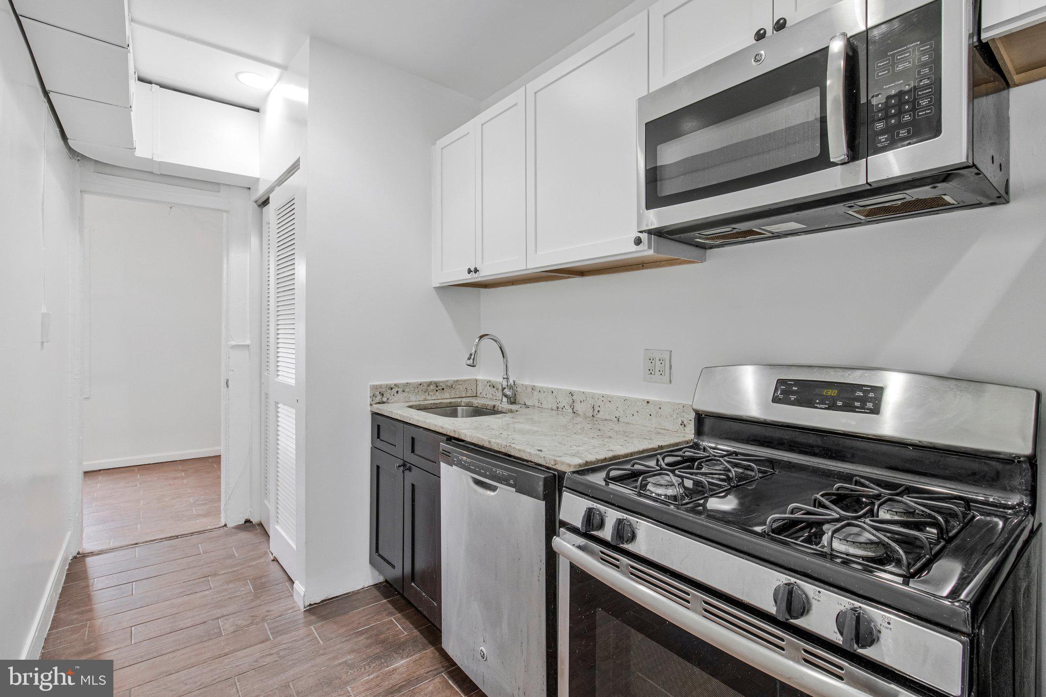 1719 West Virginia Avenue Northeast, Unit 1 Washington, DC 20002 - Photo 15 of 24 a kitchen with stainless steel appliances granite countertop a stove and a microwave