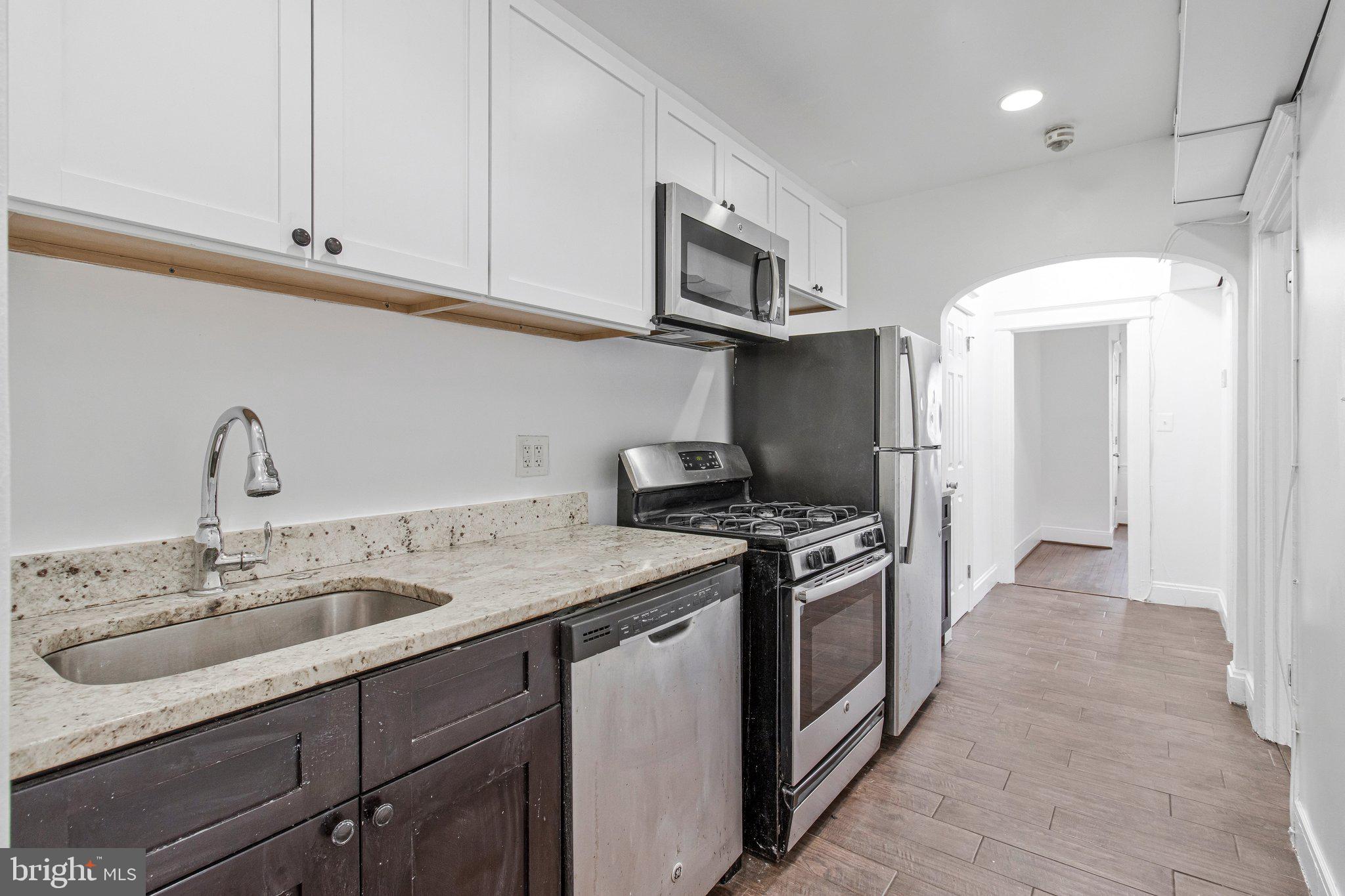 1719 West Virginia Avenue Northeast, Unit 1 Washington, DC 20002 - Photo 16 of 24 a kitchen with stainless steel appliances granite countertop a sink stove and refrigerator