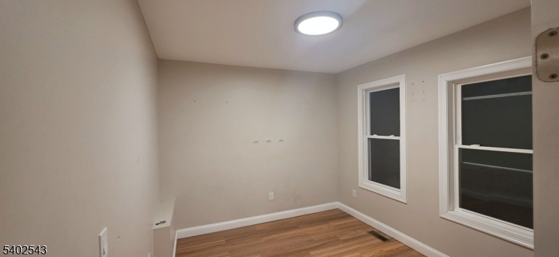 115 Wallington Avenue Wallington, NJ 07057 - Photo 11 of 13 a view of an empty room with wooden floor and a window