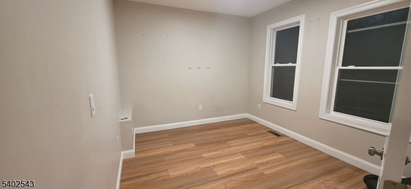 115 Wallington Avenue Wallington, NJ 07057 - Photo 12 of 13 a view of an empty room with wooden floor and a window