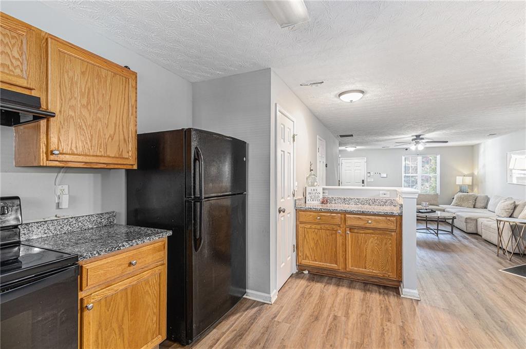 6536 Arbor Gate Drive Southwest, Unit 2 Mableton, GA 30126 - Photo 11 of 27 a kitchen with stainless steel appliances granite countertop a refrigerator and a stove top oven