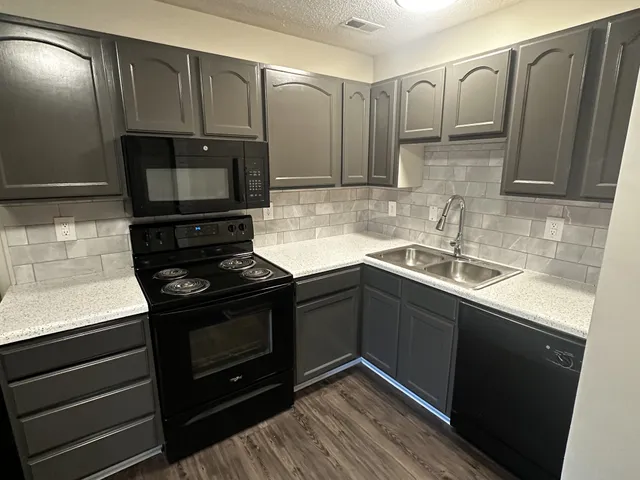 a kitchen with stainless steel appliances granite countertop a sink stove and microwave