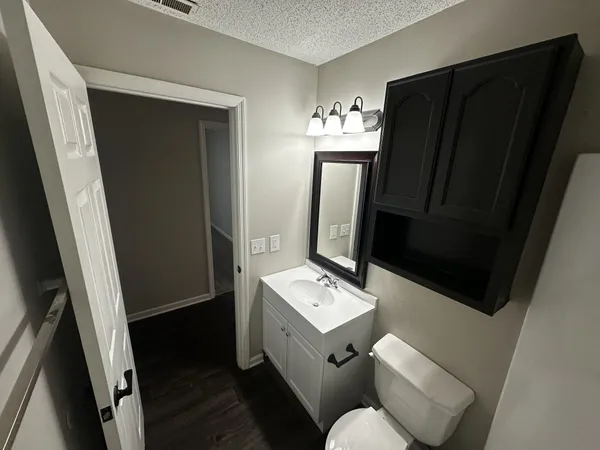 a bathroom with a sink toilet and mirror