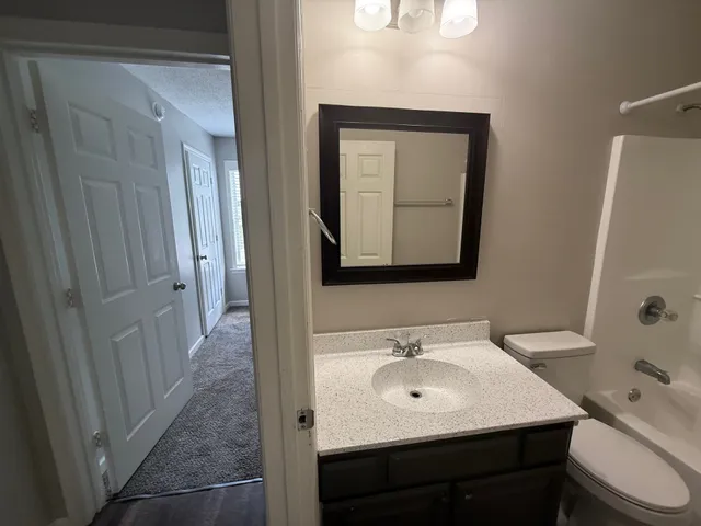a bathroom with a toilet sink and mirror