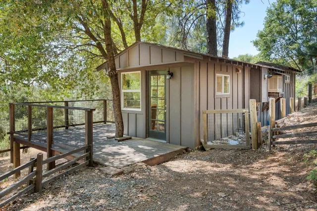a view of a house with backyard and trees