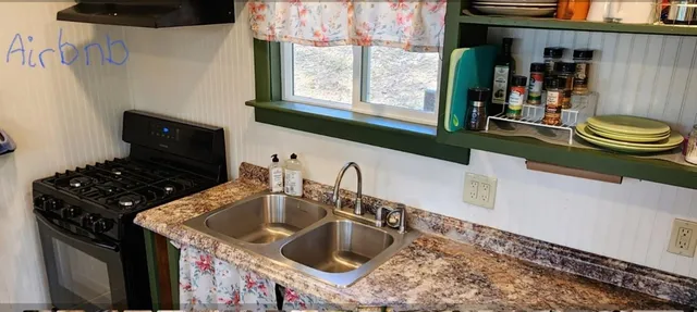 a kitchen with stainless steel appliances kitchen island granite countertop a stove top oven a sink and a microwave