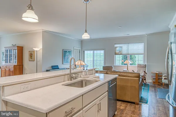a kitchen that has a sink a stove and a table with wooden floor