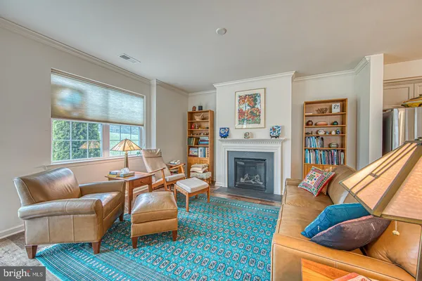 a living room with furniture fireplace and a large window