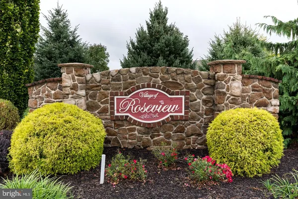 a view of a sign board with large trees