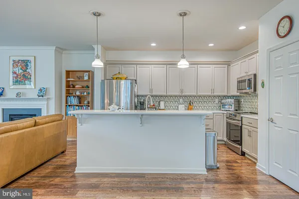 a kitchen with stainless steel appliances granite countertop a refrigerator a oven and a sink with cabinets