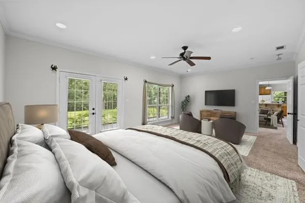 a bedroom with a bed a window and a flat screen tv