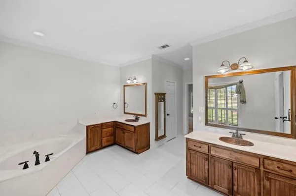 a spacious bathroom with double vanity and a bathtub