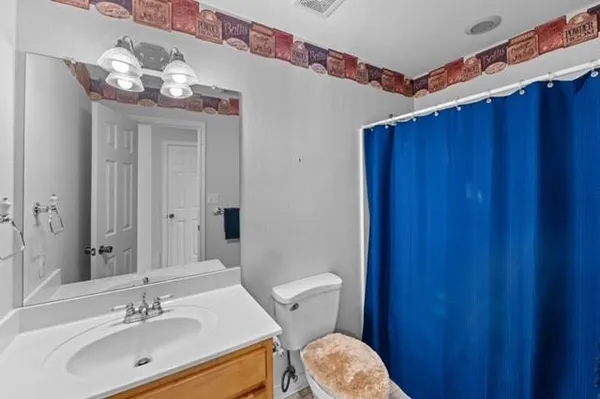 a bathroom with a sink vanity mirror and toilet