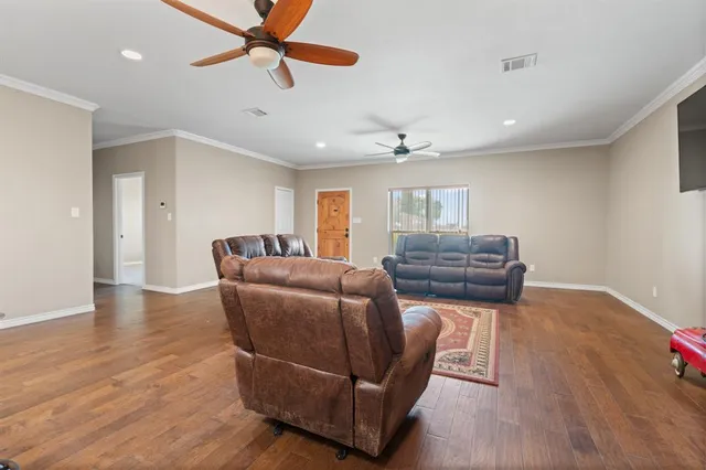 a kitchen with stainless steel appliances kitchen island granite countertop a table chairs refrigerator and microwave