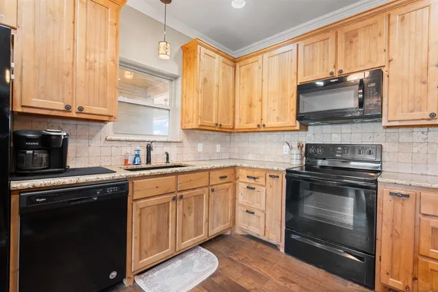 a kitchen with stainless steel appliances granite countertop a stove a sink and a microwave