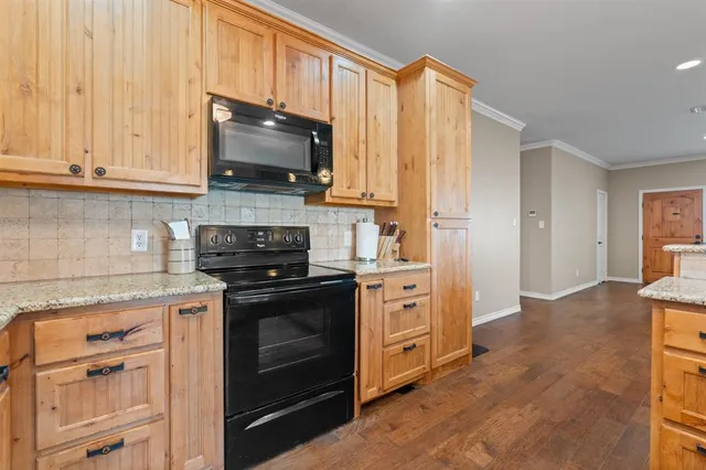 a kitchen with stainless steel appliances granite countertop a stove a sink and a microwave