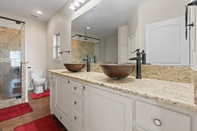 a spacious bathroom with a granite countertop sink a toilet and shower
