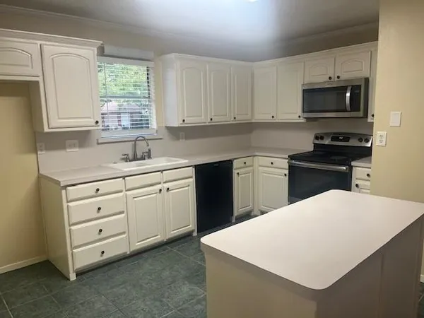 a kitchen with a white cabinets and sink