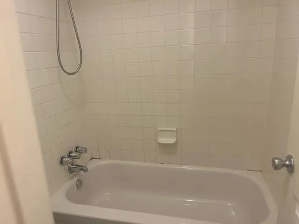 a bathroom with a white bath tub and a shower