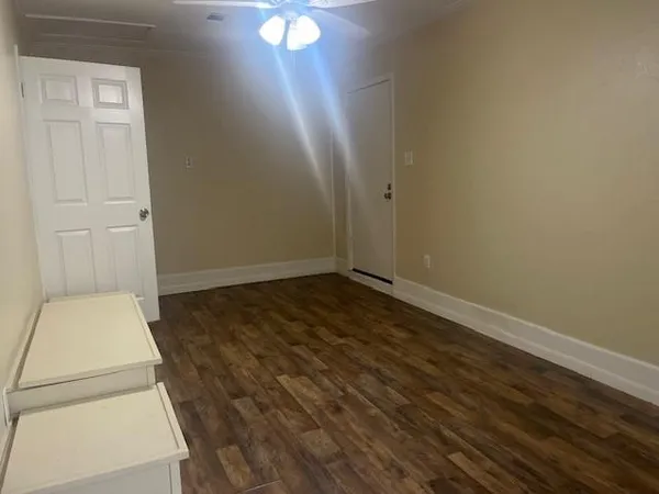 an empty room with windows and cabinet