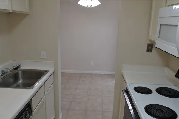 a kitchen with white cabinets and white appliances