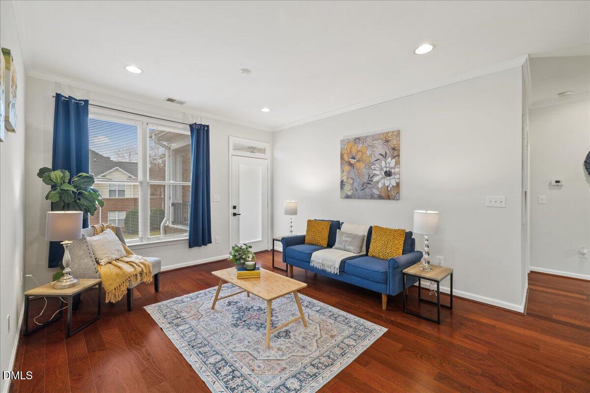 a living room with furniture and wooden floor