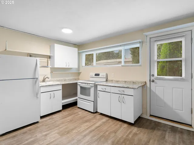 a view of a kitchen with a sink and wooden floor