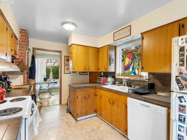 a kitchen with stainless steel appliances a stove a sink dishwasher and a refrigerator with wooden floor