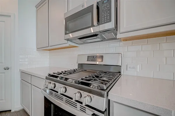 a stove top oven sitting inside of a kitchen