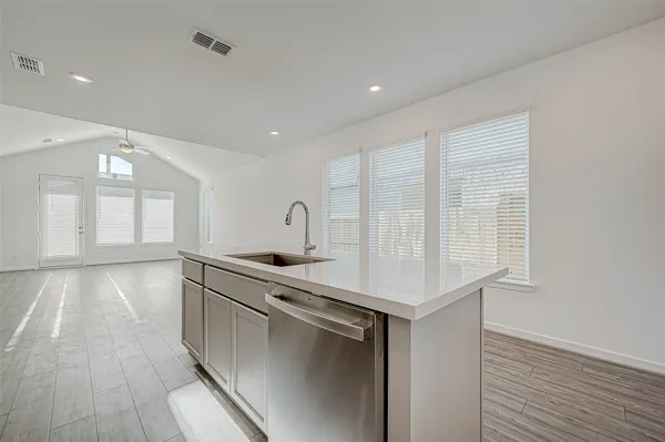 a kitchen with stainless steel appliances granite countertop a sink a stove and a wooden floors