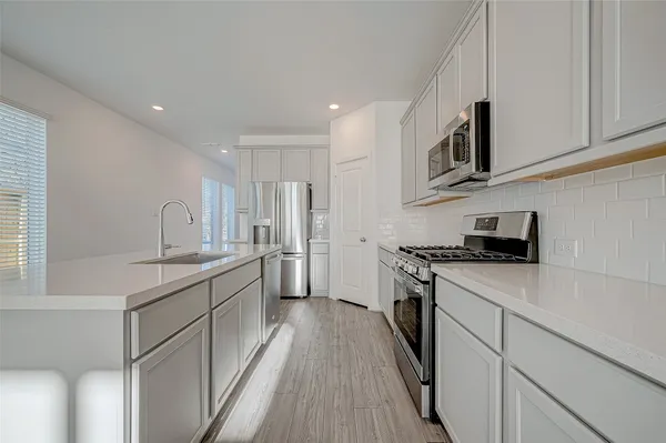 a kitchen with stainless steel appliances granite countertop a sink stove and refrigerator