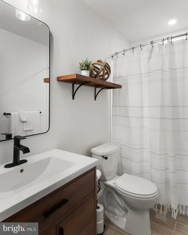 a bathroom with a sink a toilet and a mirror