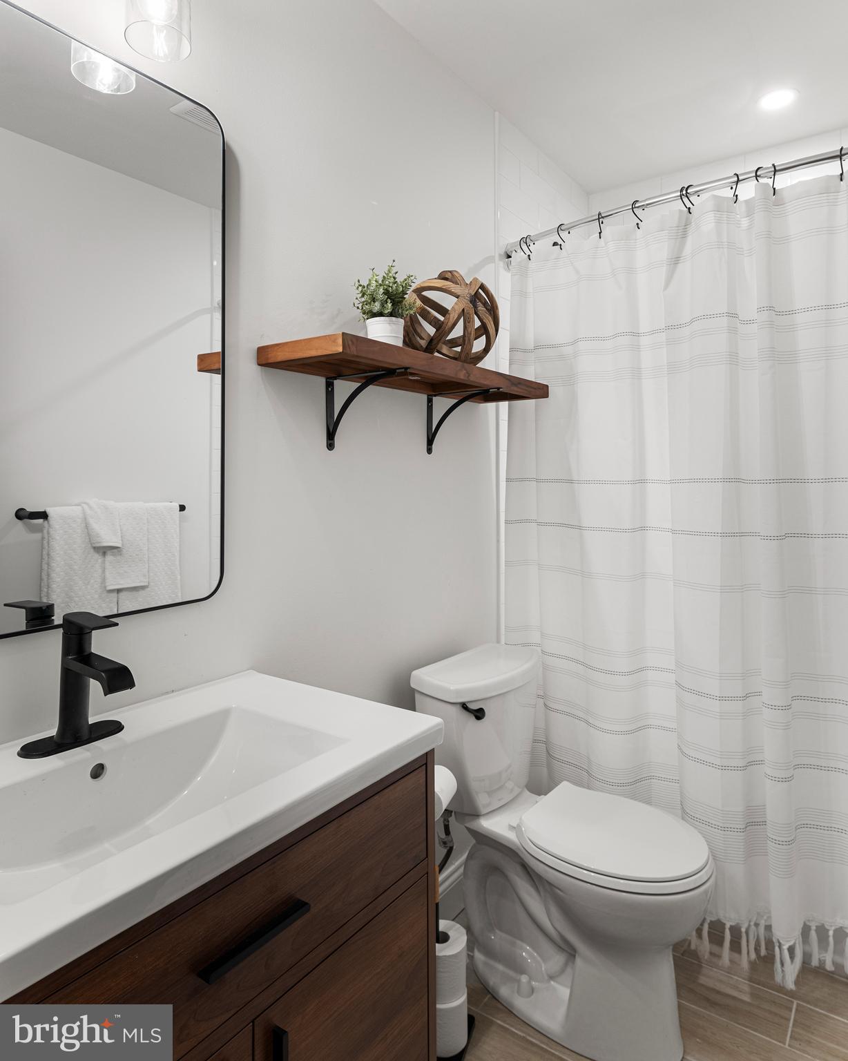 1000 West Street, Unit 200 Annapolis, MD 21401 - Photo 14 of 23 a bathroom with a sink a toilet and a mirror