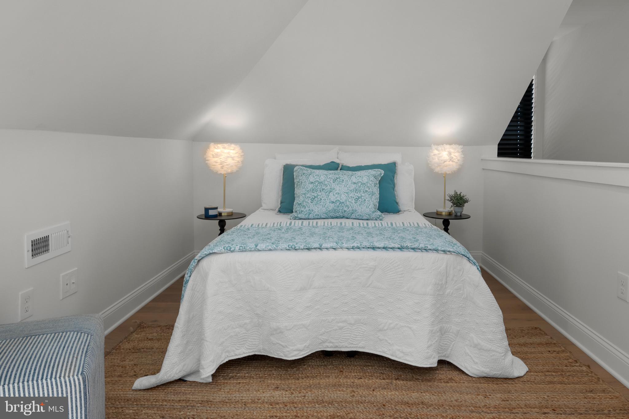 1000 West Street, Unit 200 Annapolis, MD 21401 - Photo 16 of 23 a bed sitting in a bedroom next to a lamp