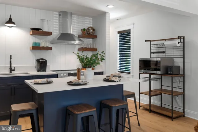 a kitchen with stainless steel appliances a sink table and chairs