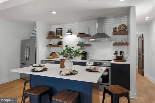 a kitchen with stainless steel appliances granite countertop a sink cabinets and wooden floor