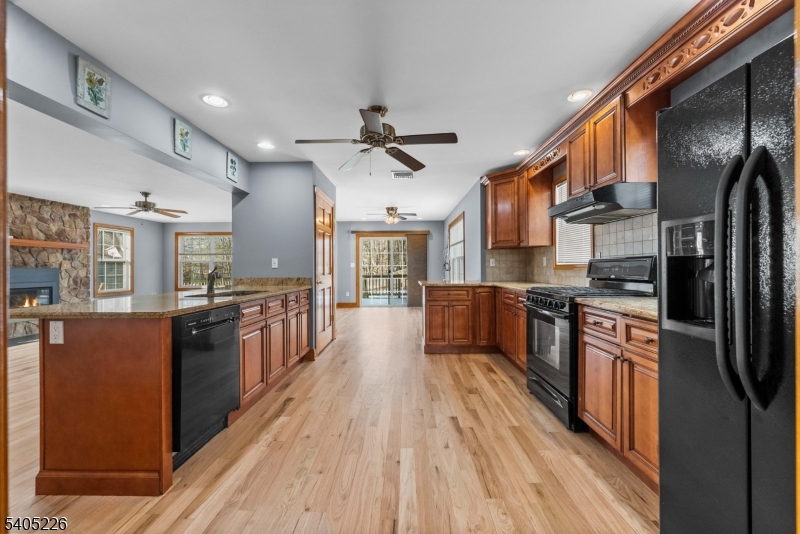 8 Kenvil Avenue Succasunna, NJ 07876 - Photo 8 of 21 a kitchen with stainless steel appliances granite countertop a refrigerator a stove top oven a sink dishwasher and wooden cabinets with wooden floor