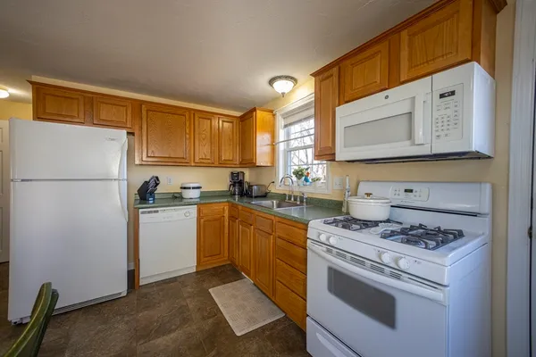 a kitchen with granite countertop a refrigerator stove top oven and sink
