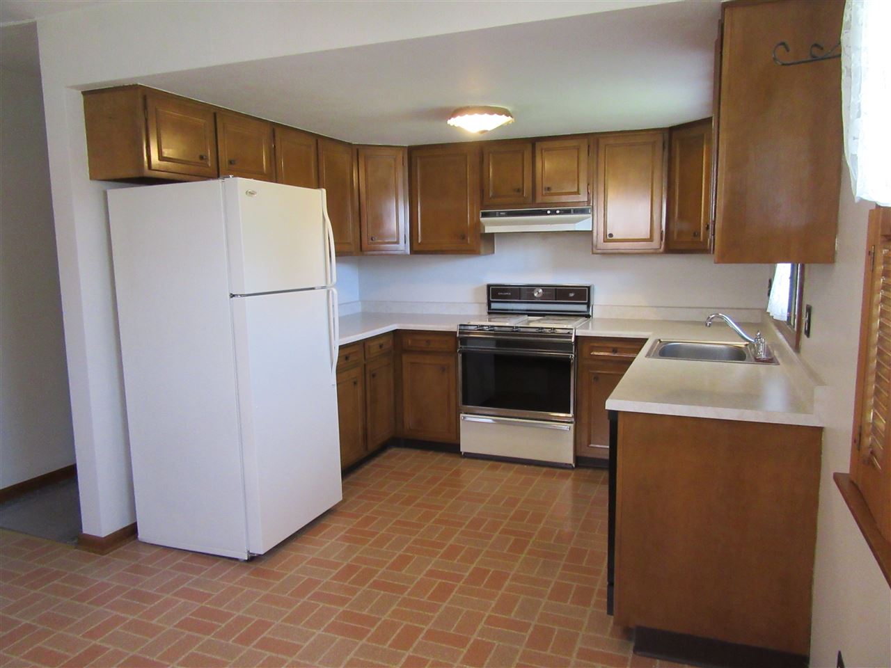 4045 Abbotsford Road Rockford, IL 61107 - Photo 6 of 18 a kitchen with a refrigerator sink and wooden cabinets