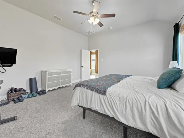 a hallway with white cabinets and dresser