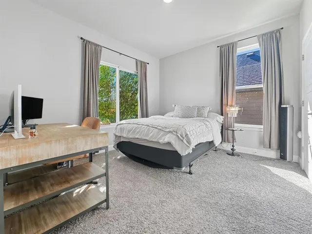 a bedroom with a bed and a large window