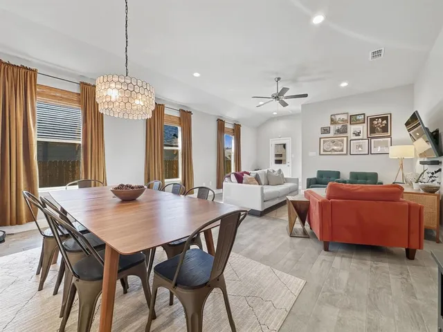 a living room with furniture a chandelier and a flat screen tv