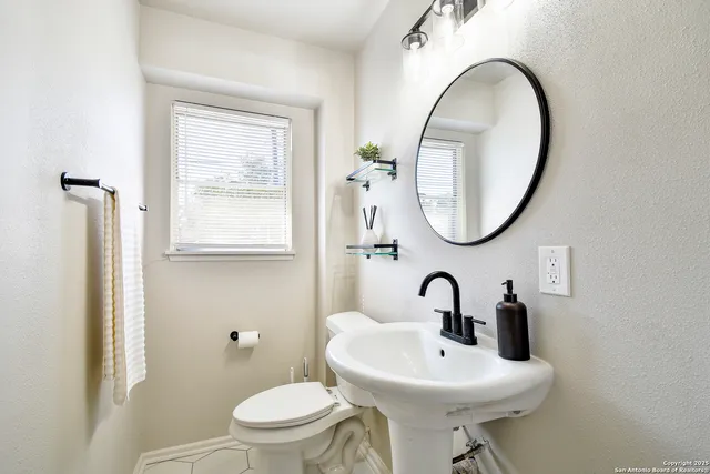 a bathroom with a toilet a sink and a mirror