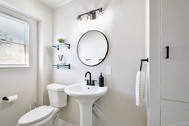 a bathroom with a toilet sink and mirror
