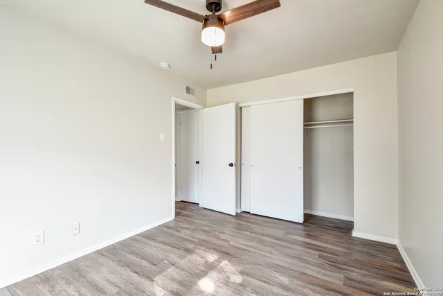 a view of an empty room with a ceiling fan
